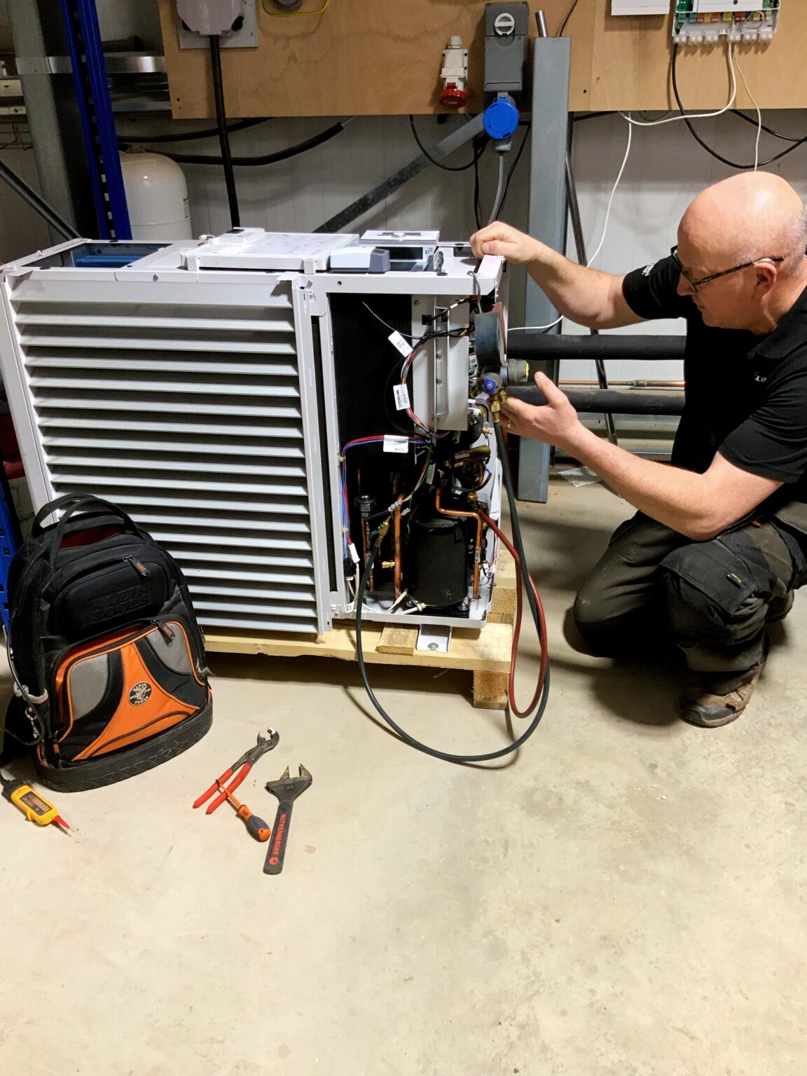 Garry Hamilton carrying out a repair on an air source heat pump in Leicestershire